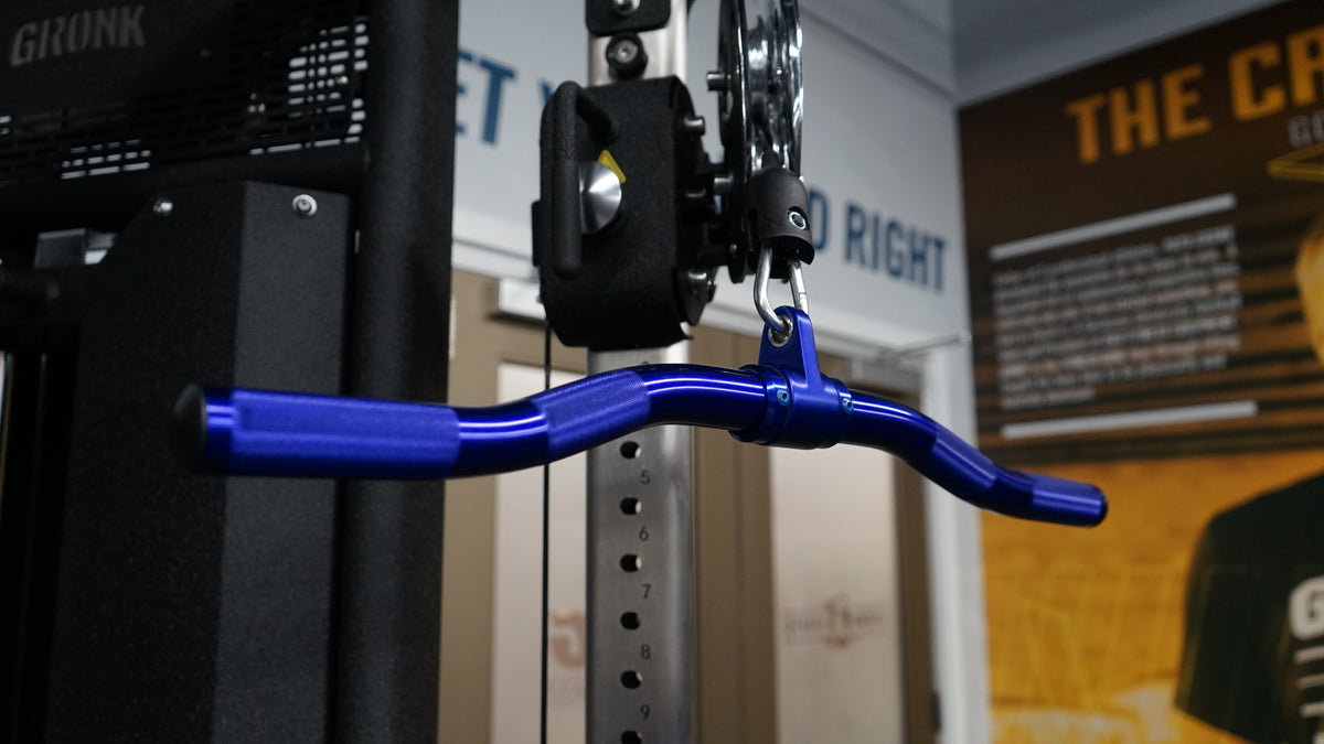 Blue anodized Gronk Fitness revolving curl bar hanging from a cable pulley on a Gronk machine