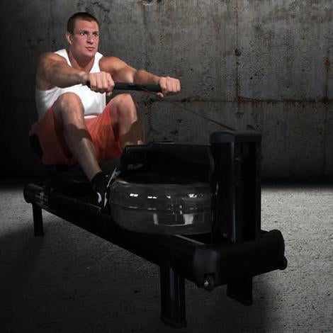 WaterRower Gronk M1 HiRise user rowing in dimly lit room