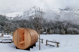 Barrel sauna outdoors in a snowy mountain setting