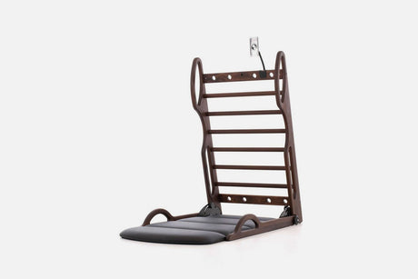 Open stretch station in dark brown wood with horizontal rungs and a dark fold-out mat