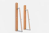 Two wall-mounted squat racks in warm golden wood, one folded shut and one opened to a silver ladder